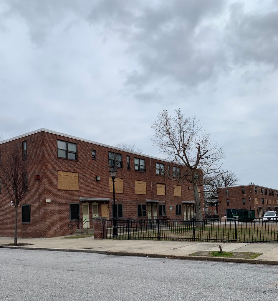 Boarded up windows on a square brick  at Perkins Homes in Baltimore